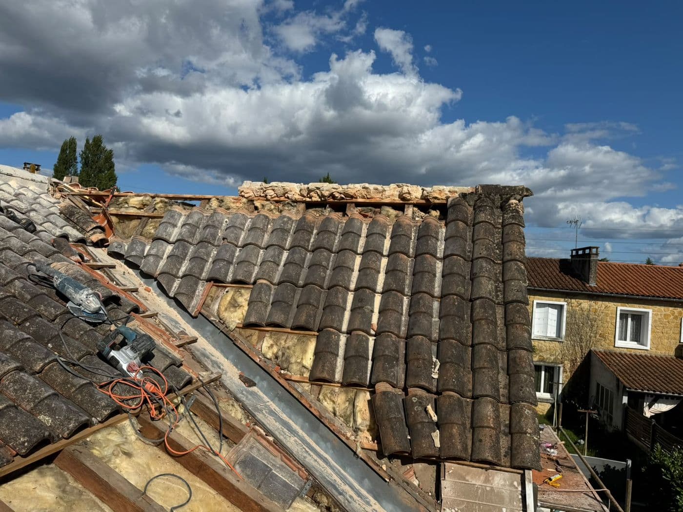 Toiture ancienne et faîtage dégradé en milieu urbain